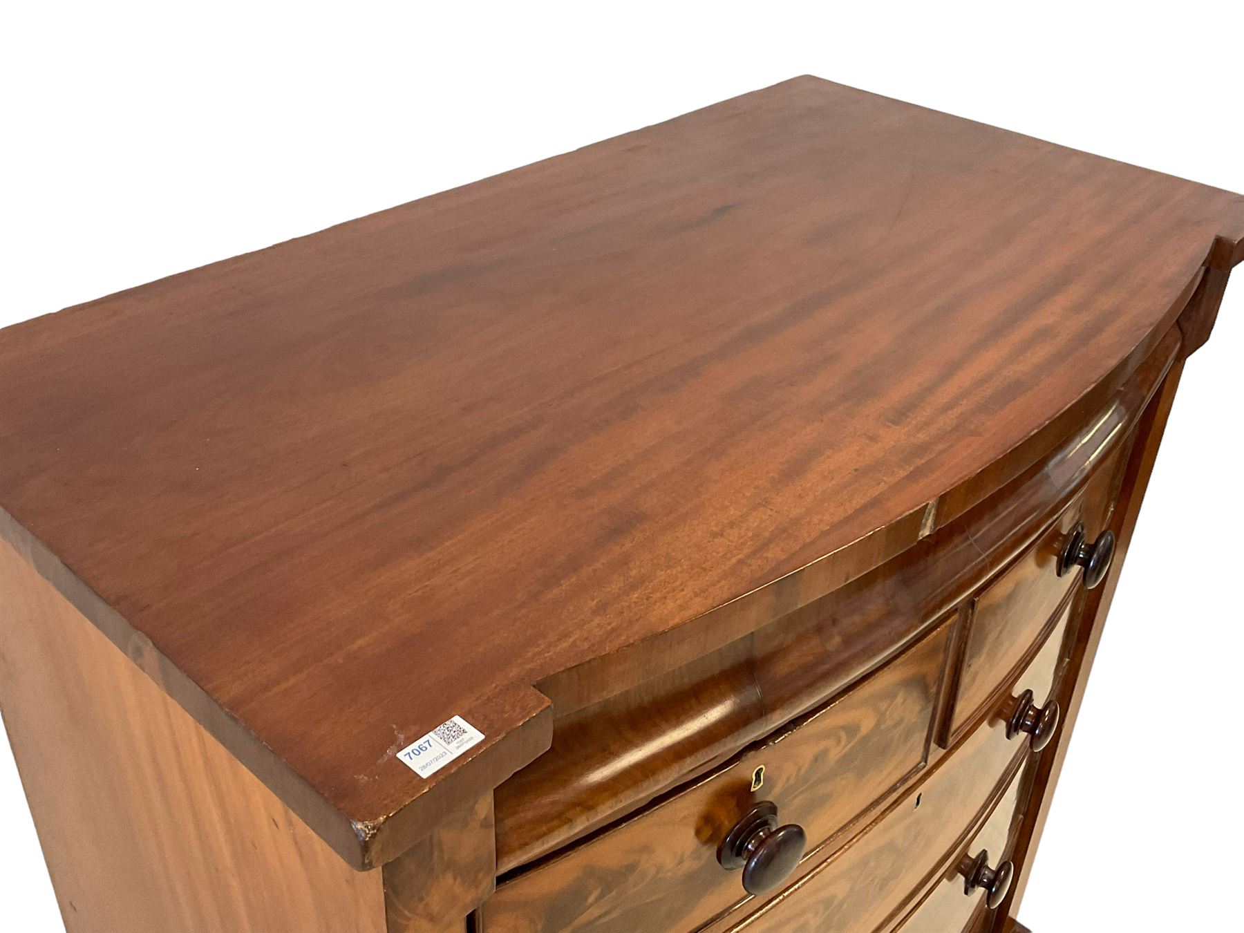 Late 19th century mahogany bow-front chest, fitted with banded cushion drawer with secret catch, above two short over three long graduating drawers, each cock-beaded with turned handles, lower moulded edge over turned feet