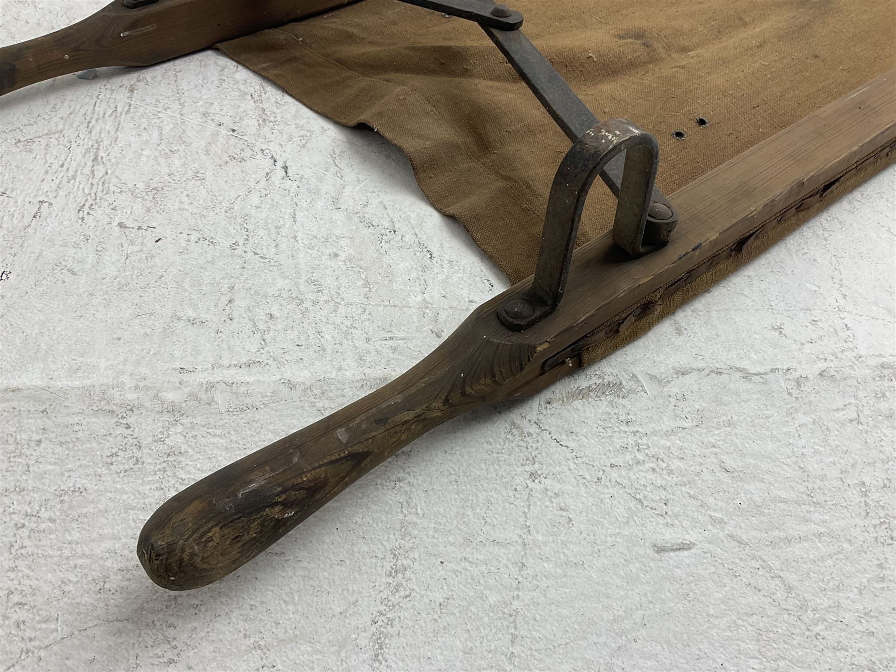 WW1 British casualty stretcher with iron mounted pitch pine sides and canvas base; stamped 'HL1917' and L7 with broad arrow in a triangle L236cm ( reputedly recovered from a barn at Bapaume on The Somme)