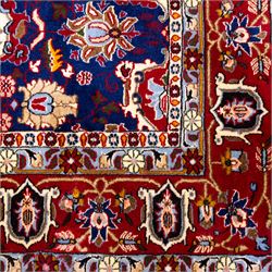 North Central Persian Veramin hand-knotted rug, deep indigo field decorated with an all-over lattice of stylized floral and palmette motifs issuing from an angular vine ornament, enclosed by a broad madder-red border of palmettes and scrolling vine devices between multiple guard stripes, with cotton fringe ends 