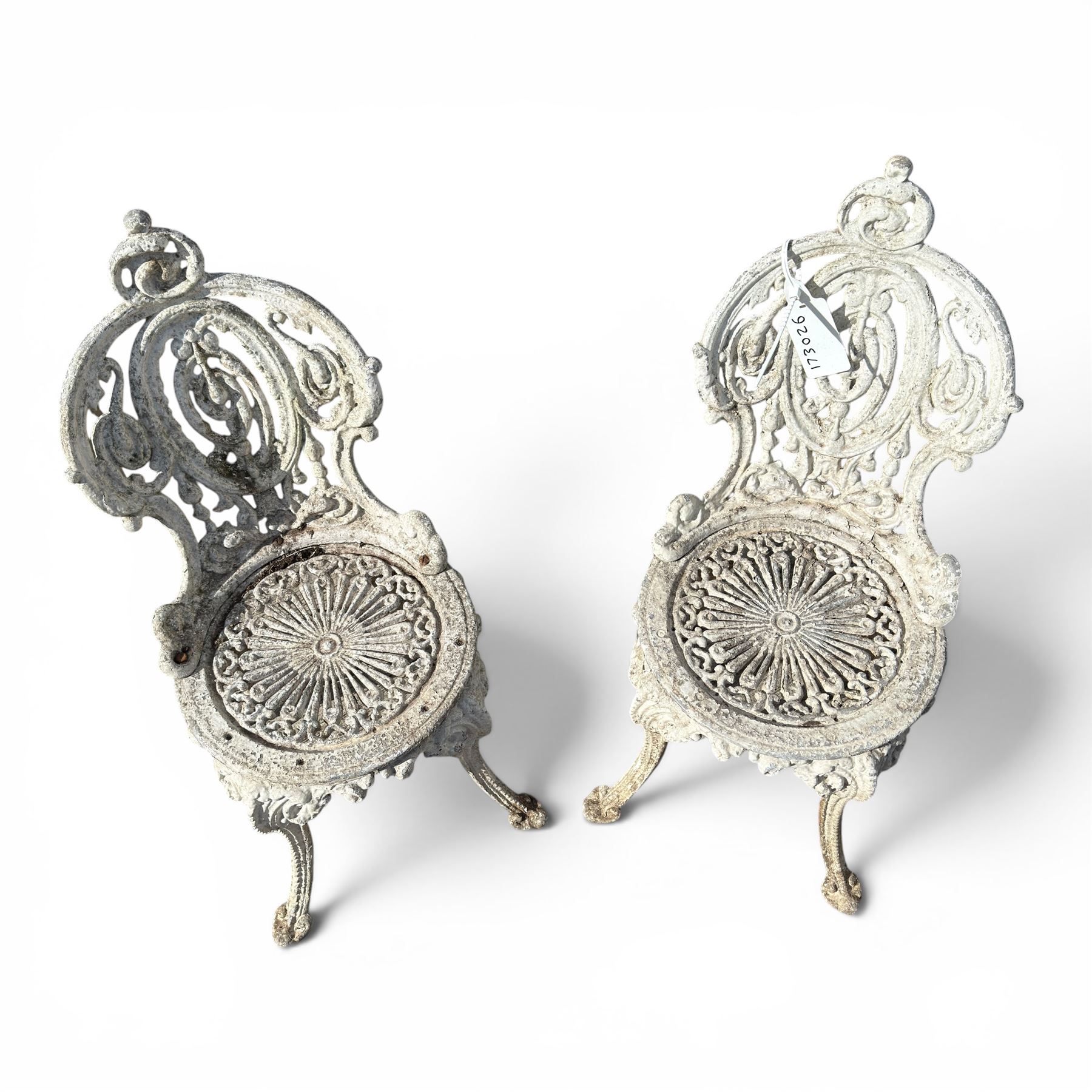 Pair of white painted cast metal garden chairs, ornate reclined backs, circular pierced seats on cabriole legs