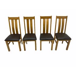 Solid oak oval extending dining table, butterfly leaf extension, four chairs with brown upholstered seats