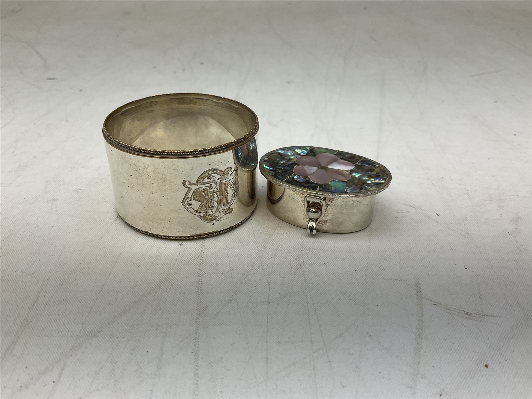 French silver plated wine taster of typical form, stamped, together with a silver plated napkin ring, and an 'Alpaca Silver' pill box with mother of pearl detailed cover, (3)