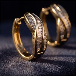 Pair of 14ct gold diamond crossover hoop earrings, each set with tapered baguette and round brilliant cut diamonds, stamped
