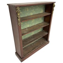 Early 20th century mahogany open bookcase, fitted with three shelves on plinth base, decorated with foliate patterned gilt metal mounts