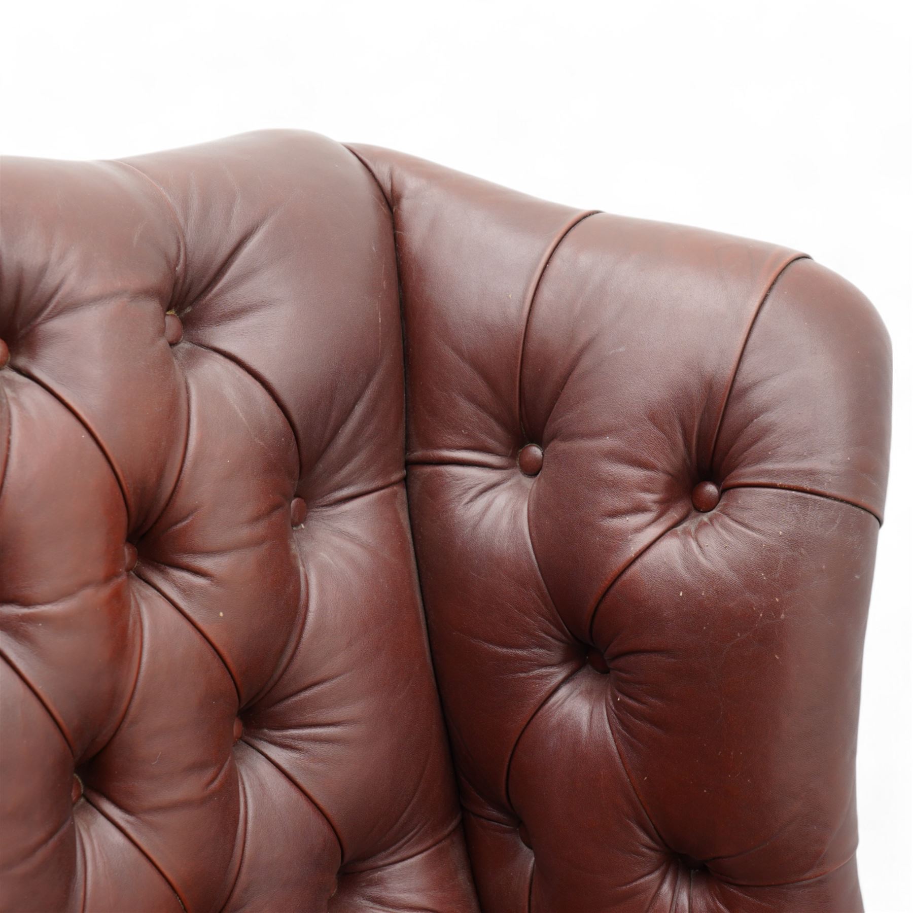 Georgian design leather wingback armchair, deep-buttoned burgundy leather upholstery with rolled arms, studded detail along the edges, raised on cabriole supports terminating in claw and ball feet
