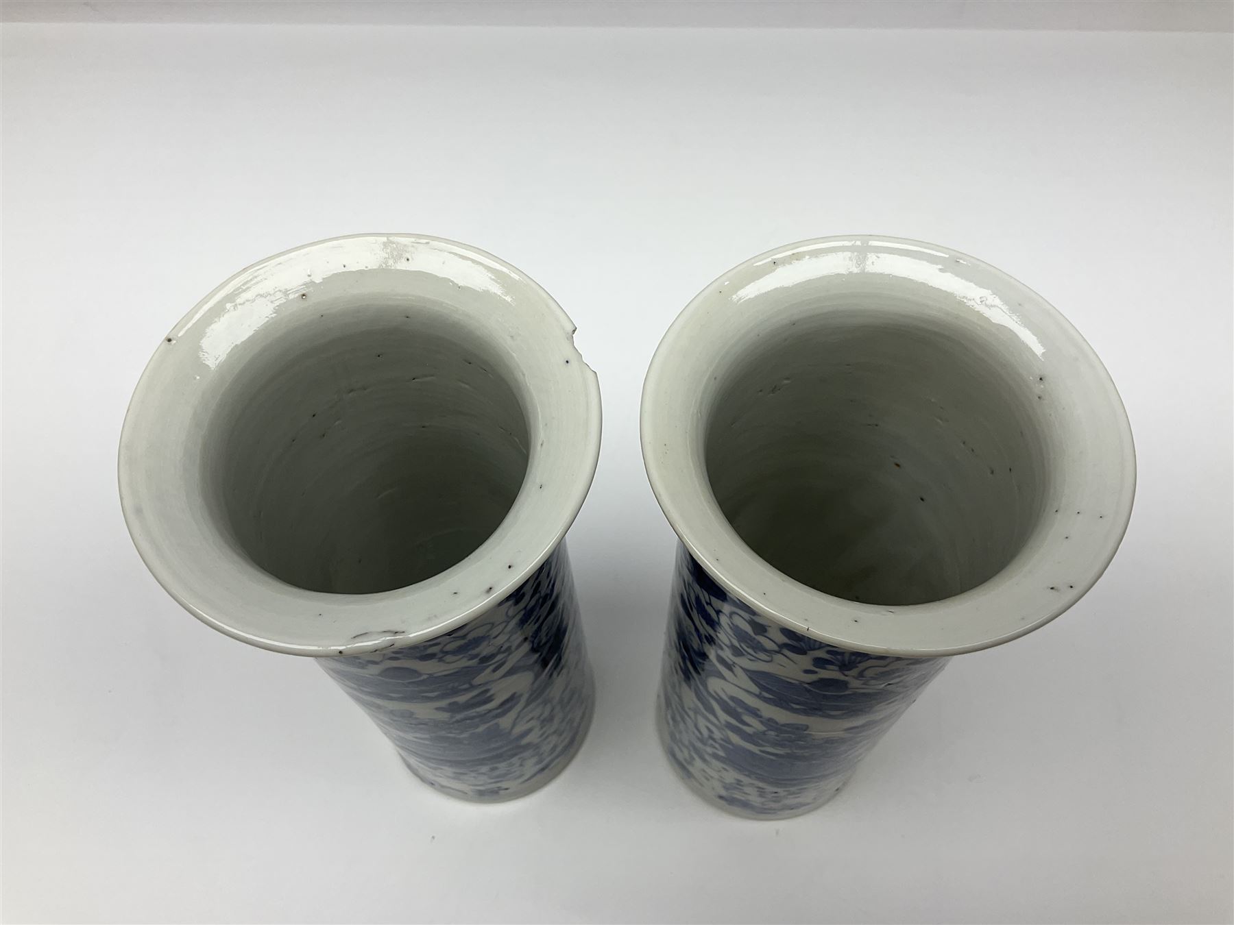 Pair of Chinese blue and white cylindrical vases, decorated with bird and flowers surrounding central figures holding a large vase, H20cm