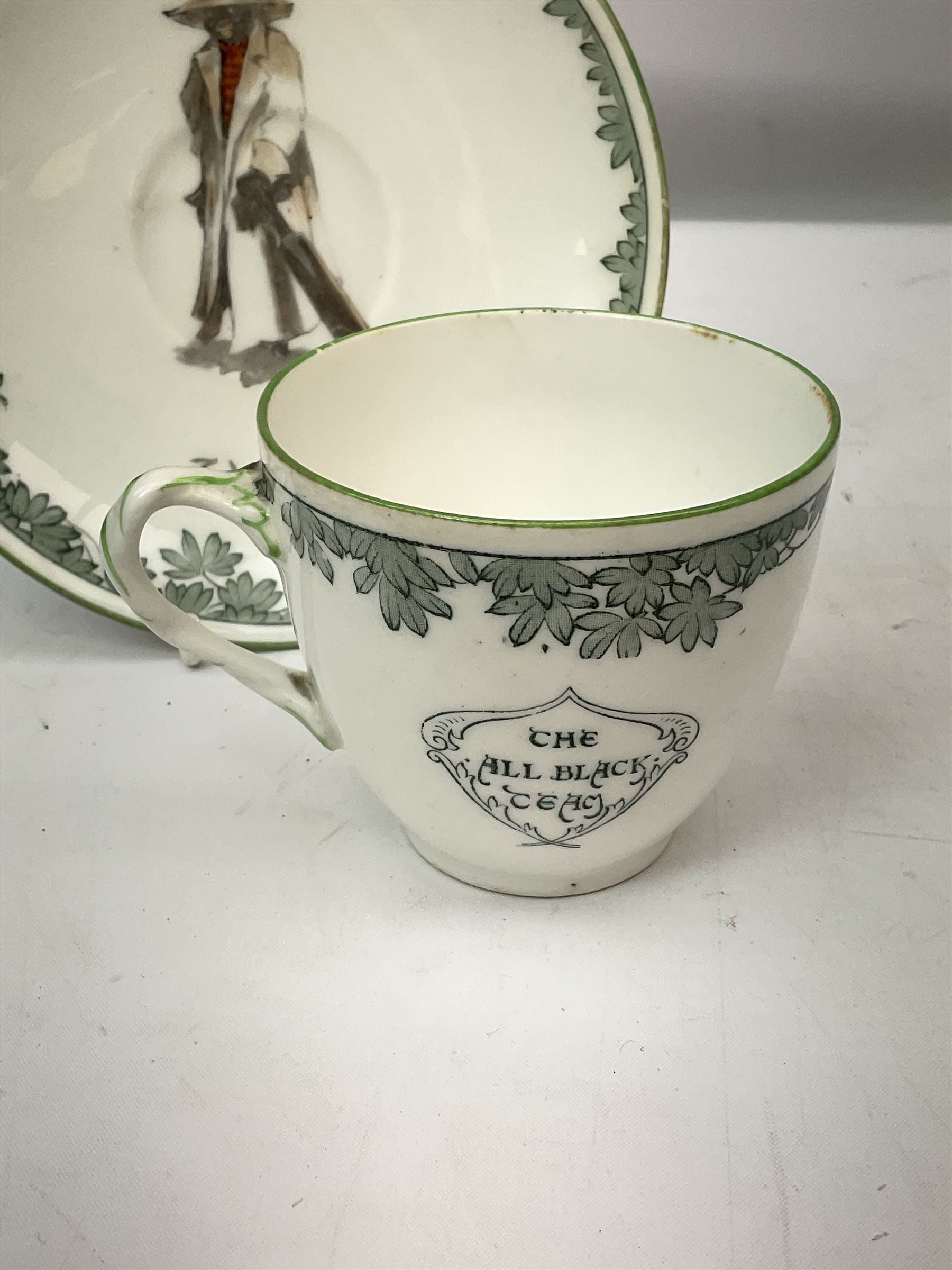 Early 20th century Royal Doulton teacup and saucer, from the series 'The All Black Team', the teacup depicting a cricketer entitled 'Good for fifty', the saucer depicting a cricketer stood in a long coat and wide brimmed hat, entitled 'The Boss', both with printed mark beneath, cup H6.5cm