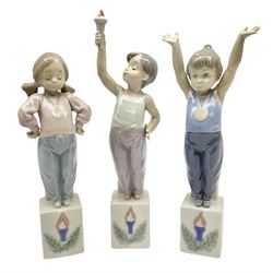 Lladro Olympic figures set, comprising Olympic Torch no 5870, Olympic Champion no 5871 and Olympic Pride no 5872, all with original boxes, largest example H25cm 