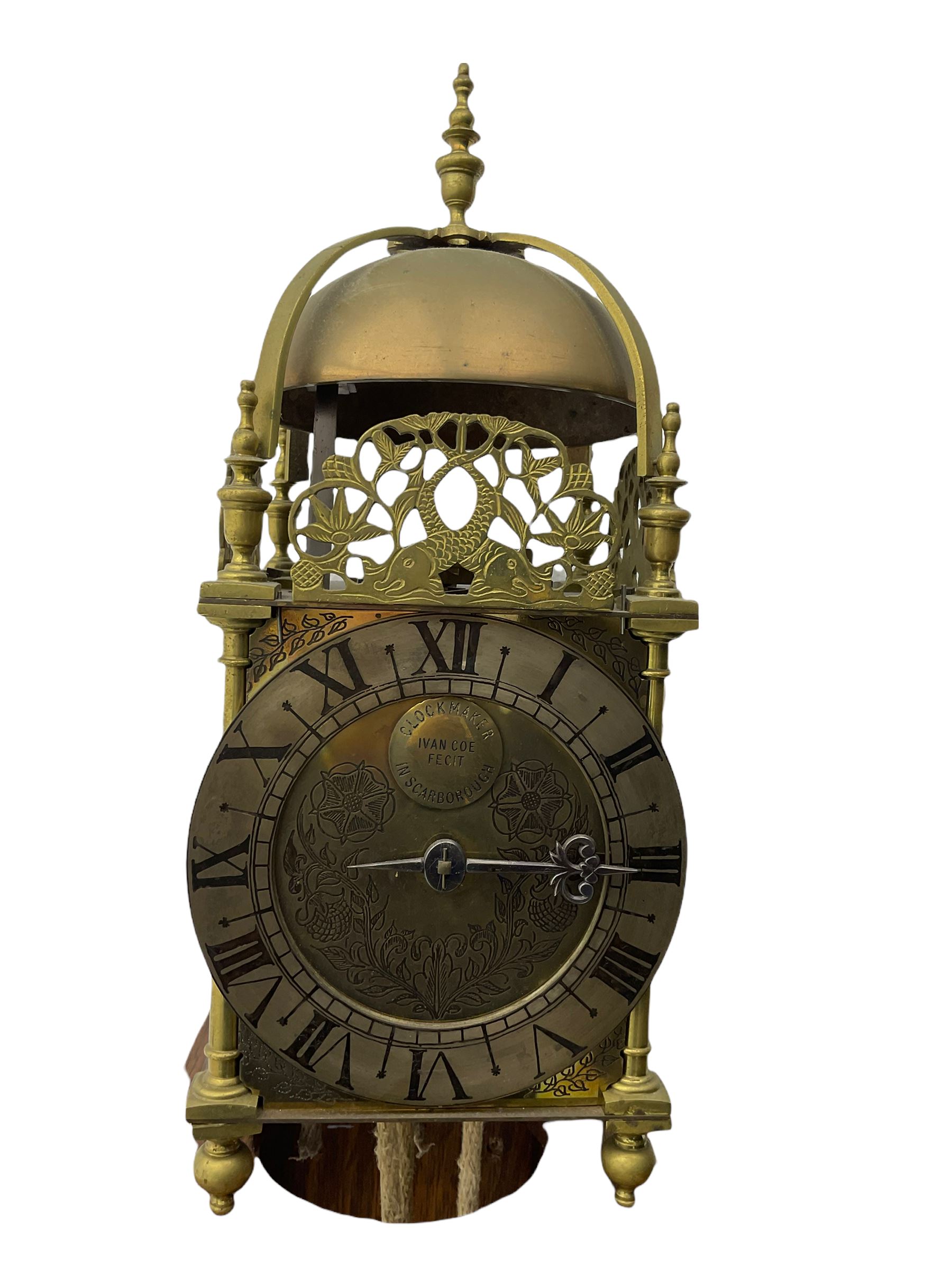 A 20th century replica of a 17th century 30-hour lantern clock with a rope driven verge escapement and countwheel striking, sounding the hours on a bell, with an engraved dial centre, silvered chapter ring and Roman numerals , half hour and quarter hour markers and a pierced and fettled steel hand, with an attached disc engraved “ Clockmaker In Scarborough Ivan Coe, Fecit,”, with engraved side doors, brass finials and dolphin fretwork, on a wooden bracket with pulley.   No weight.
Clocks similar to this were usually individually constructed by engineers working from plans of clocks designed by Claude Reeve, John Wilding, Malcolm Timings and other well-known clockmakers/engineers. 
