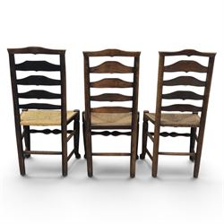 Set of seven (6+1) Georgian design country elm Lancashire dining chairs, ladder backs with rush seats, turned front leg stretcher on pad feet, height of seat 44cm, complete with fitted tie on cushions