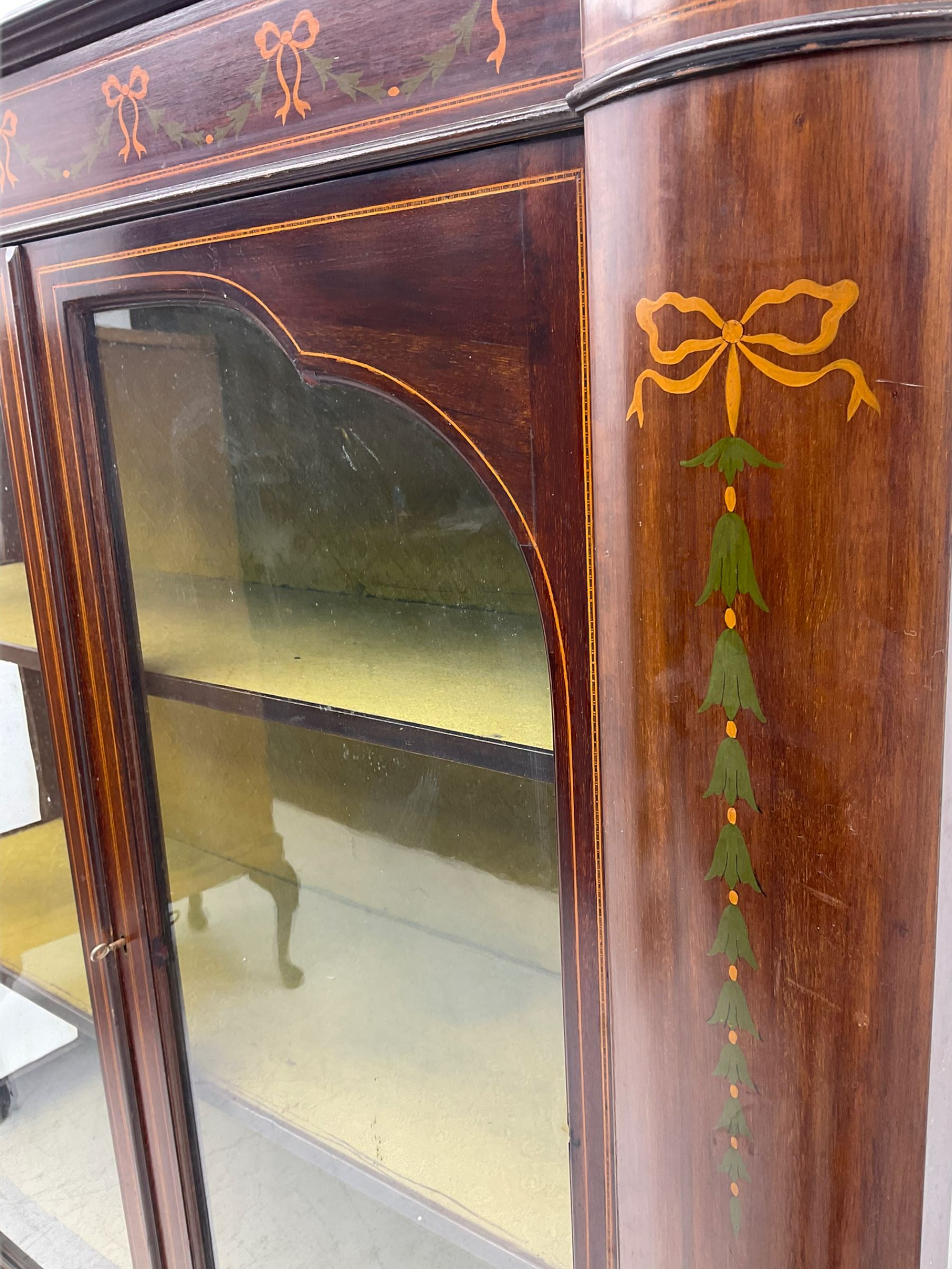 Edwardian mahogany display cabinet, shaped front with painted ribbon and bellflower garland decoration, enclosed by two glazed doors, cabriole supports