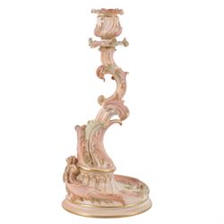 Royal Worcester pair of blush ivory candlesticks, modelled in the rococo style of scrolling foliate design upon a circular spreading base, gilt-heightened, puce mark to base and numbered RN160134 and 1478, H32cm