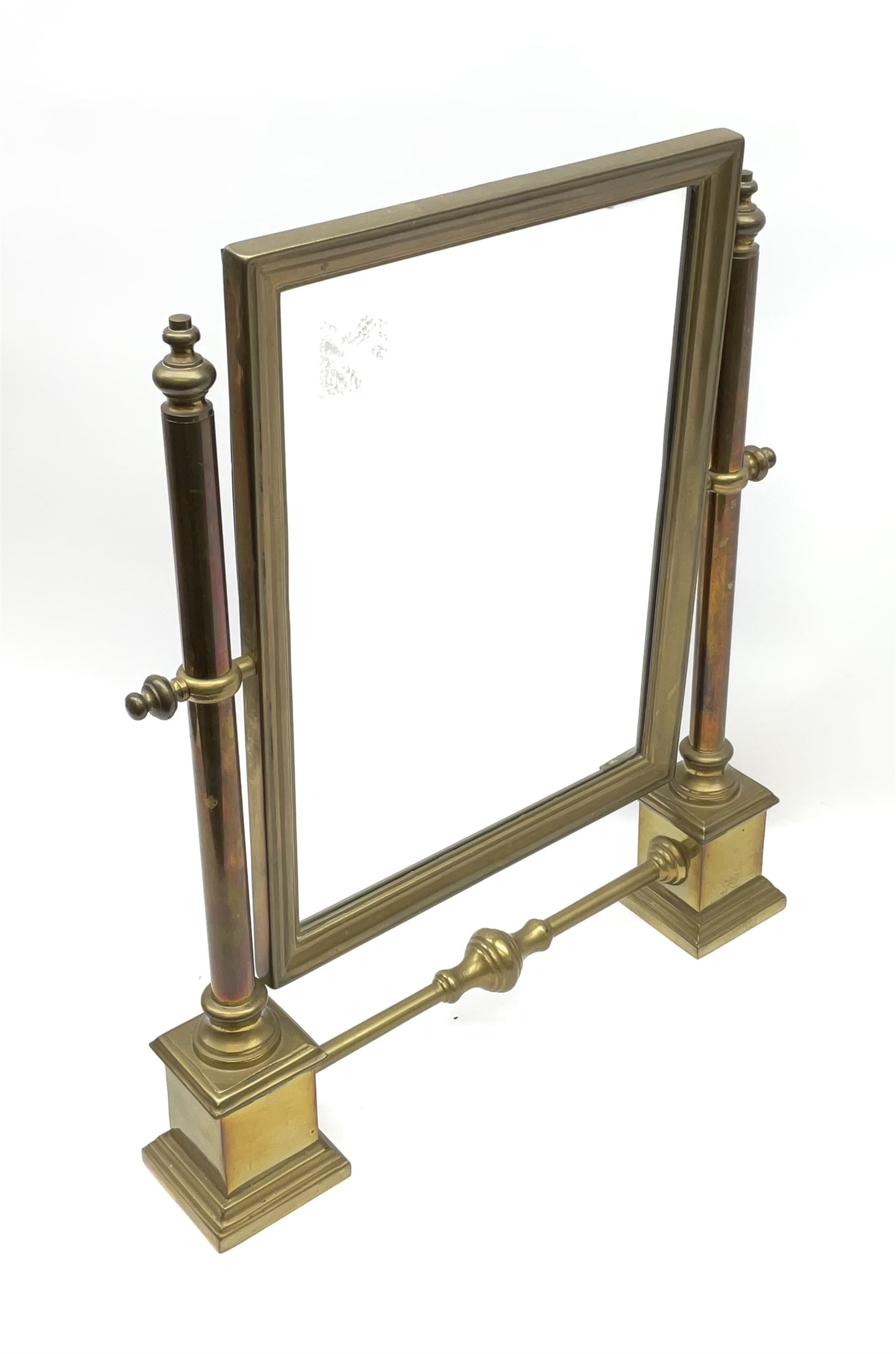 A brass table top swing mirror, upon stepped supports with stretcher, H41.4cm L34.5cm.