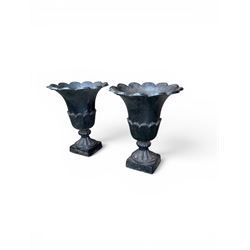 Pair of Victorian large scale cast iron garden urns, flared petal shaped rim with tapering waist, gadrooned base on square plinth, finished in black paint