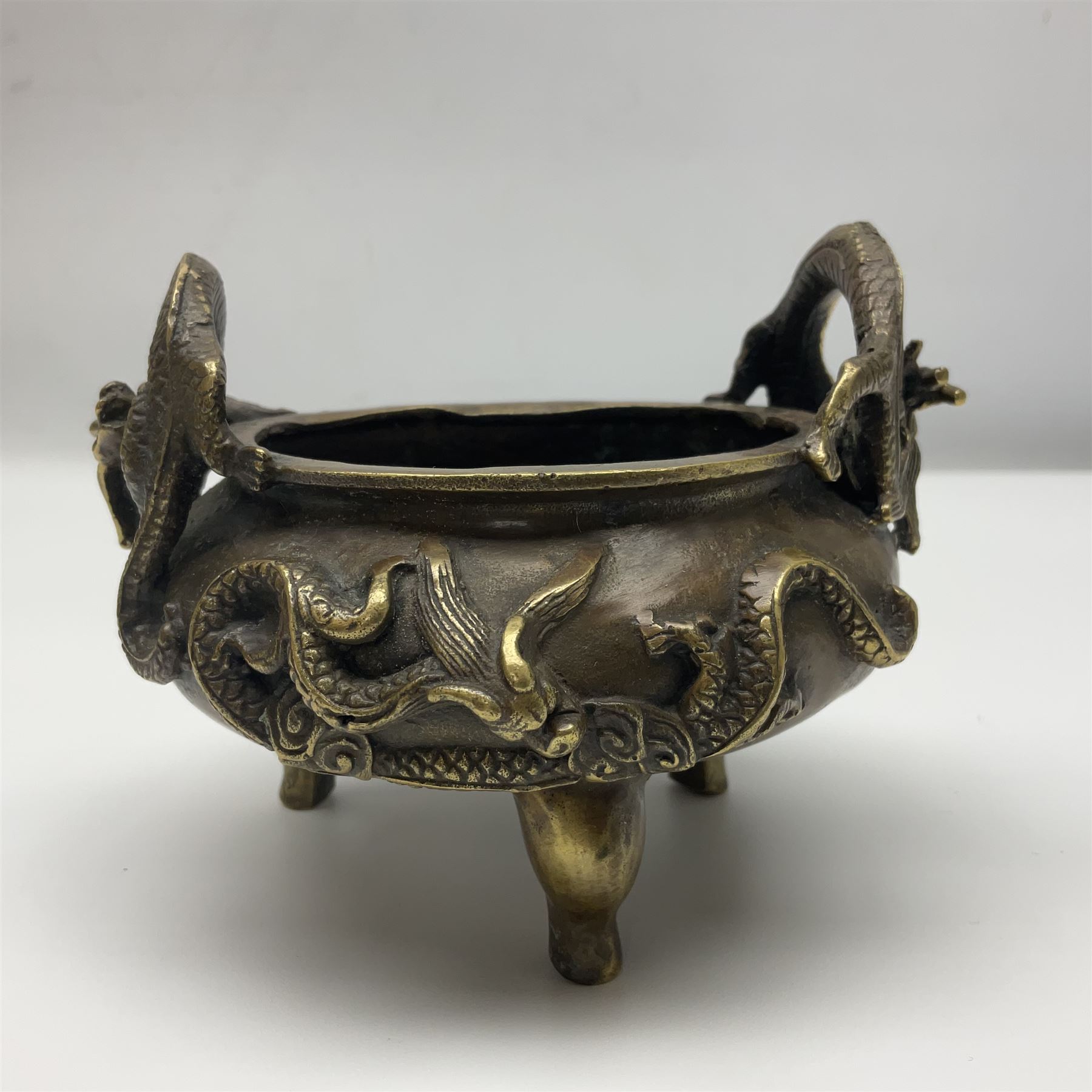 Chinese cast brass censer, with applied dragon twin handles and decoration, raised upon three feet with character mark beneath, D12cm H9.5cm
