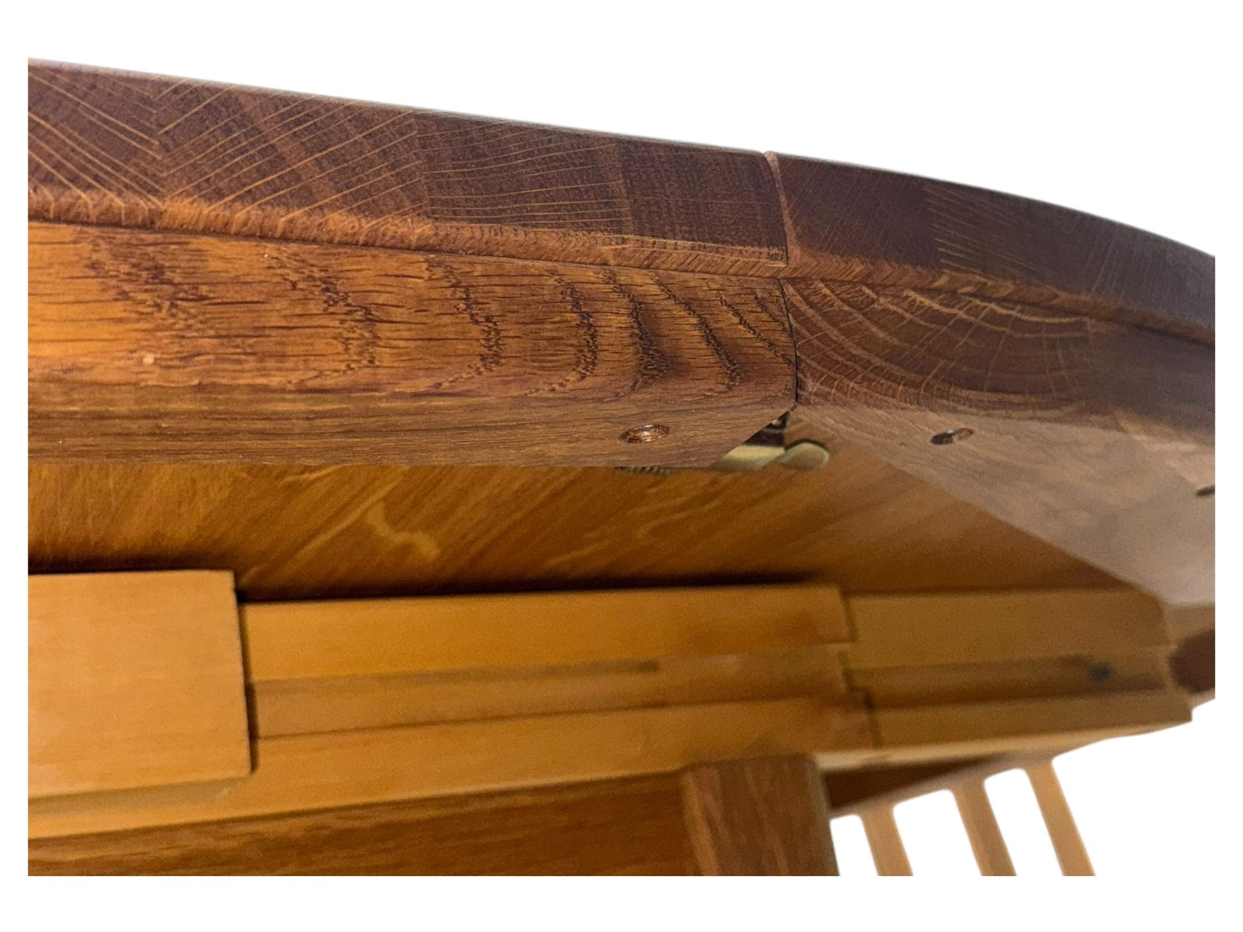 Contemporary light oak round extending dining table with four chairs, table has fold out leaf attached underneath on four out-swept legs, Oak chairs with straight top rail over twin slat back with pierced motifs, brown leather seat with brass studs, square legs joined by plain stretcher 