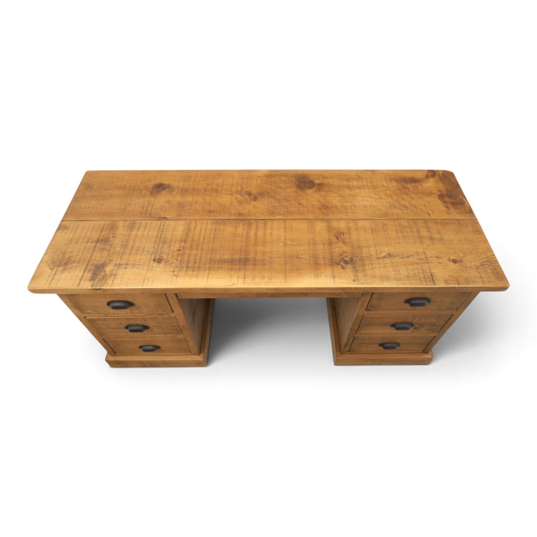 Indigo Furniture - rustic oak twin pedestal desk, rectangular plank top, with central frieze drawer, the fixed pedestals with three drawers and metal cup handles, raised on a plinth base