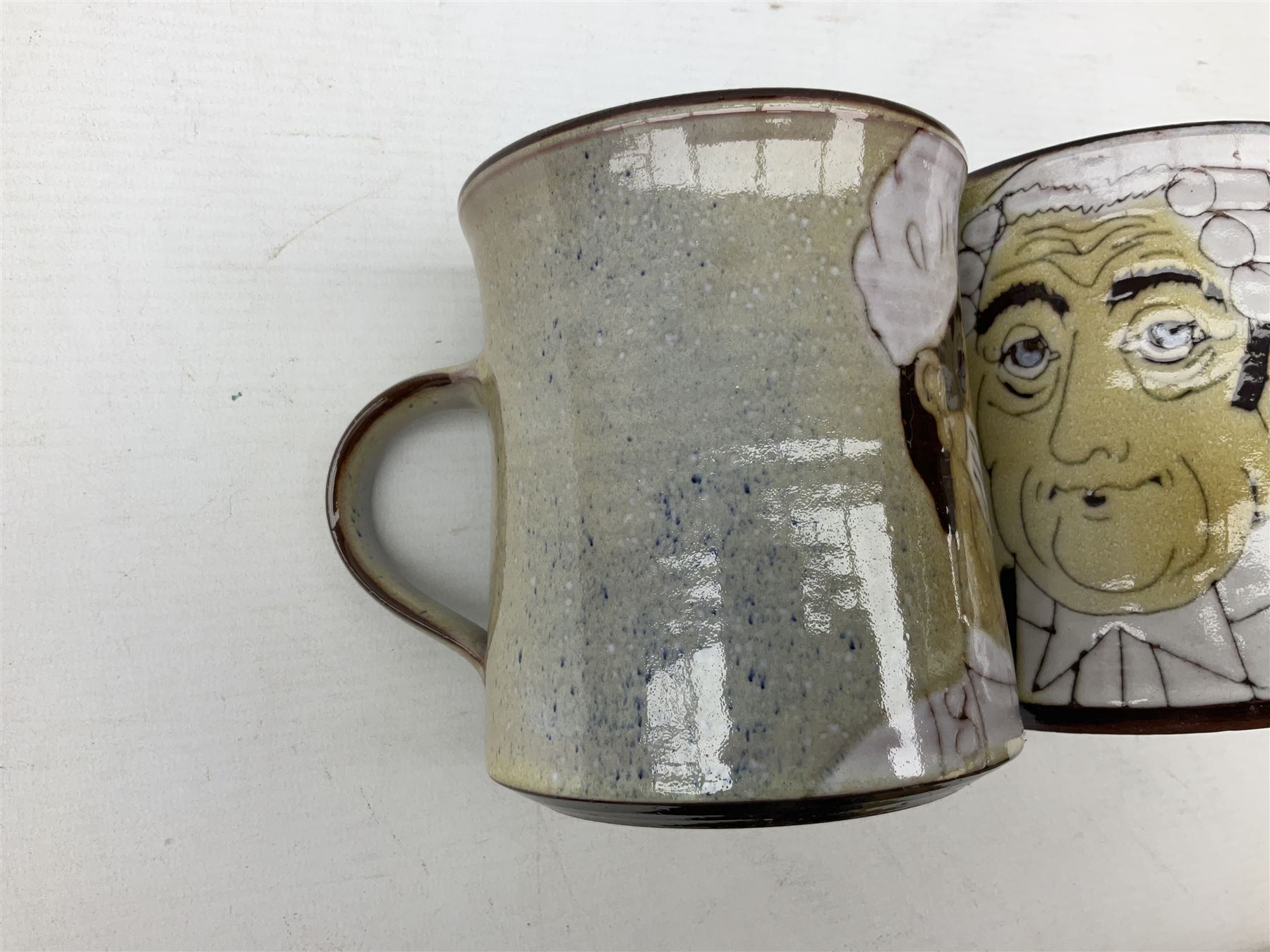 1960s Chelsea Pottery mug decorated with barrister by Joyce Morgan, signed JEM, together with a similar example depicting a doctor, H11.5cm, both signed beneath