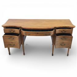 Early 20th century mahogany bow front sideboard, the shaped and moulded top above central kneehole recess with baize lined frieze drawer, flanked by twos drawers either side with the lower drawer double height, raised upon square tapering legs with spade feet