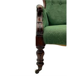 Early Victorian armchair, the shaped back buttoned in green upholstery, scroll carved arm terminals, turned and carved supports with brass castors 