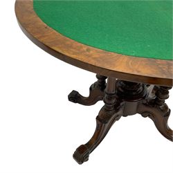 Victorian figured walnut demi-dune card table, the fold-over moulded top with circular baize lining, on four turned pillars with central finial platform, four splayed moulded supports with angular scrolled feet, on castors