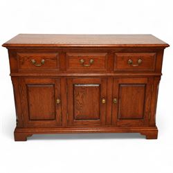 20th-century oak side cabinet, rectangular top above an arrangement of three drawers and three panelled cupboard doors, fitted with brass knobs, raised on bracket feet  
