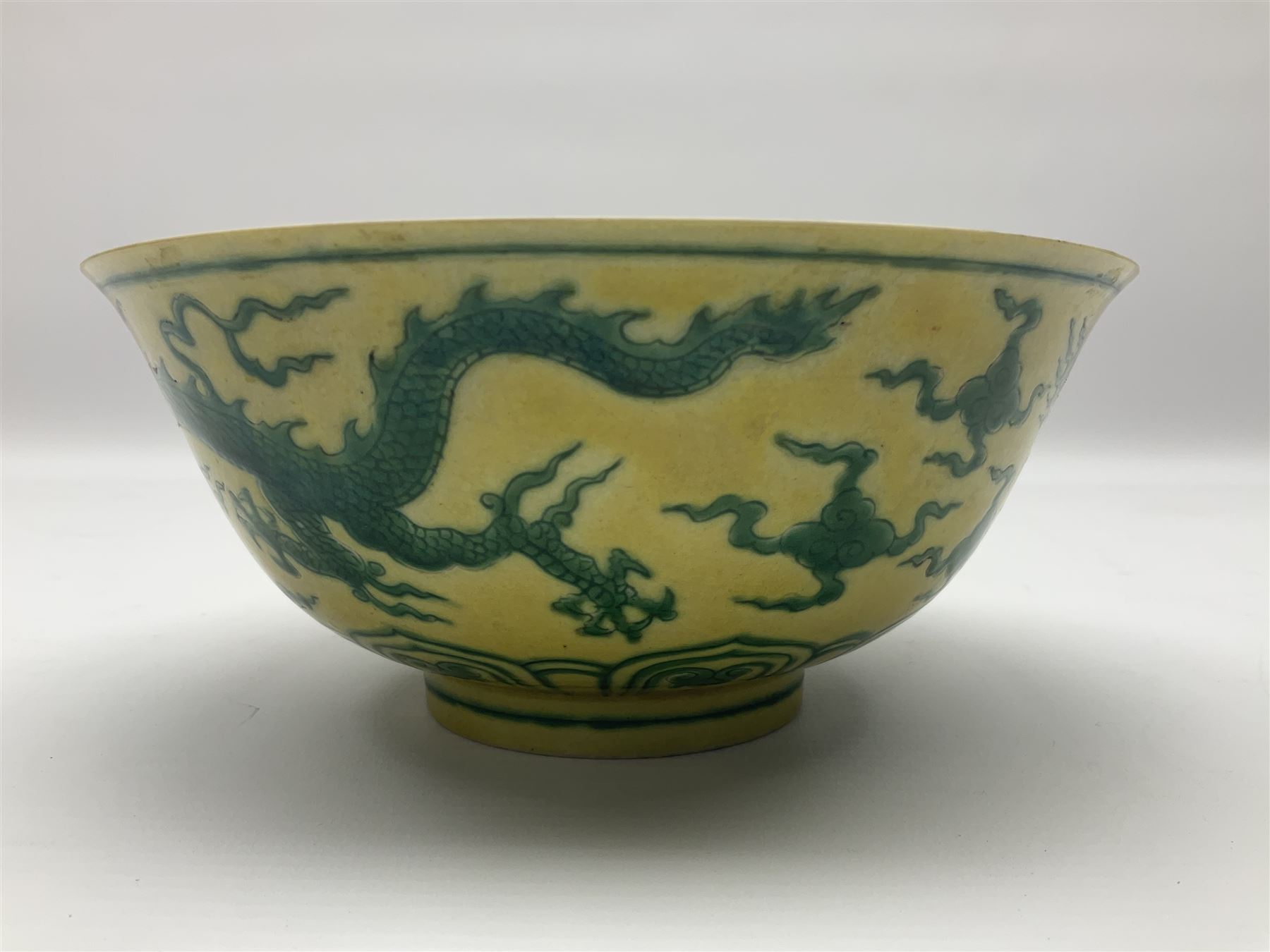 Pair of Chinese famille jaune bowls, decorated in green enamel with a dragon chasing a flaming pearl amongst clouds, upon a yellow ground, the interior decorated to centre with dragon, with six character mark beneath, D17.5cm