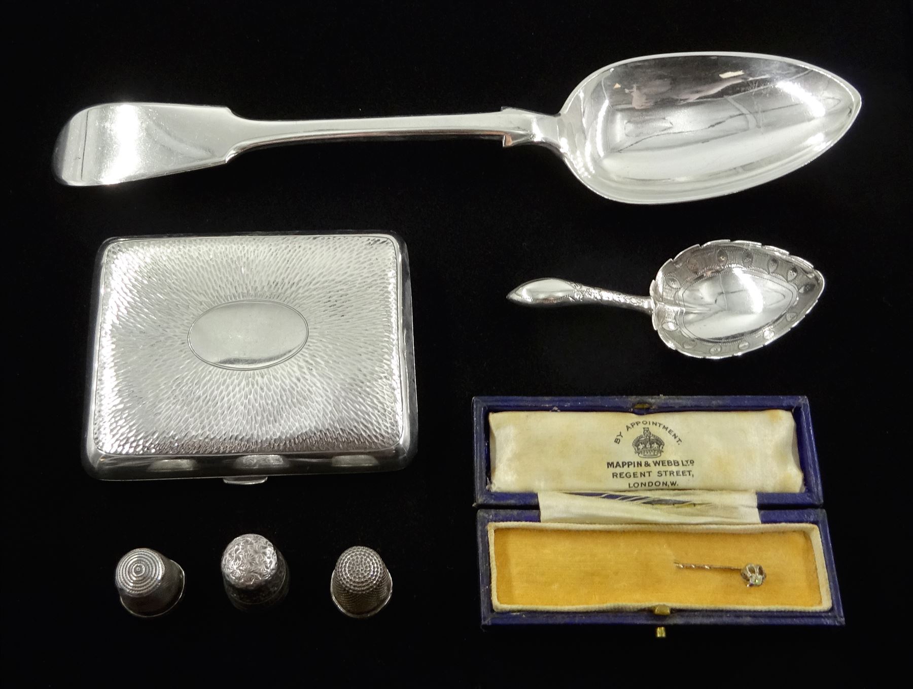 George III silver heart shaped caddy spoon, makers mark IT, Birmingham 1812, gold diamond stick pin, silver cigarette case by Henry Matthews, Birmingham 1906, three silver thimbles and a silver table spoon Fiddle pattern  by John Stone, Exeter 1842