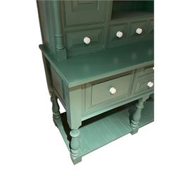Large contemporary teal green painted kitchen dresser, projecting cornice over three open shelves flanked by cupboard with five spice drawers below, the base fitted with four assorted drawers, raised on turned vasiform supports united by undertier
