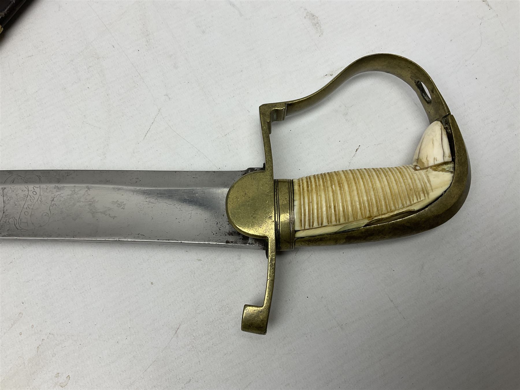 British pattern 1796 Light Cavalry Officer's sword, the 83.5cm curving steel blade marked 'W. Parker London' and 'Warranted' verso, brass stirrup hilt with half-round langets, knucklebow and backstrap with ribbed ivory grip; in brass mounted leather covered scabbard with two suspension rings L97cm overall. This item has been registered for sale under Section 10 of the APHA Ivory Act 