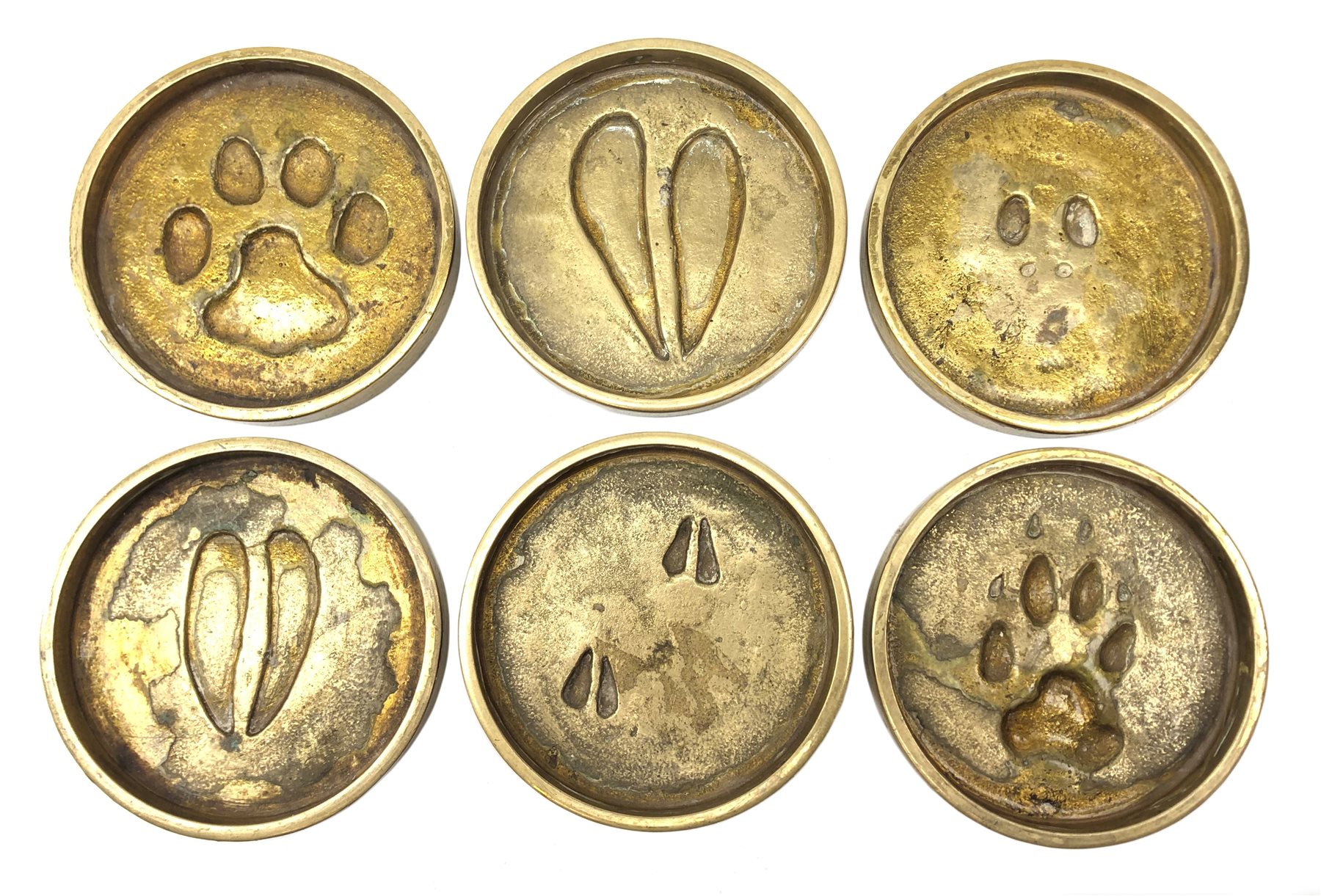 Rowland Ward (British Taxidermist: 1848–1912), set of six African Animal brass paw print coasters, comprising Jackal, Klipspringer, Damaraland Dik Dik, Bushbuck, Impala and Serval Cat, signed beneath, D8cm   