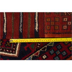 Two hand-knotted rugs, comprising Persian runner and Turkoman prayer rug, Persian hand-knotted runner, red and dark navy ground with four diamond medallions and geometric motifs, enclosed by multicoloured geometric border, striped kilim ends with fringes, H244cm, W58cm; Turkoman hand-knotted prayer rug, ivory mihrab field decorated with repeating stylised geometric motifs, enclosed by multiple geometric borders in madder red and brown, with fringed ends, H150cm, W93cm