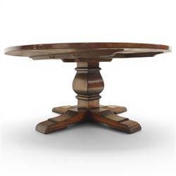 Early 20th century oak centre table, the large circular top raised on a squared and turned baluster pedestal, terminating to four splayed supports