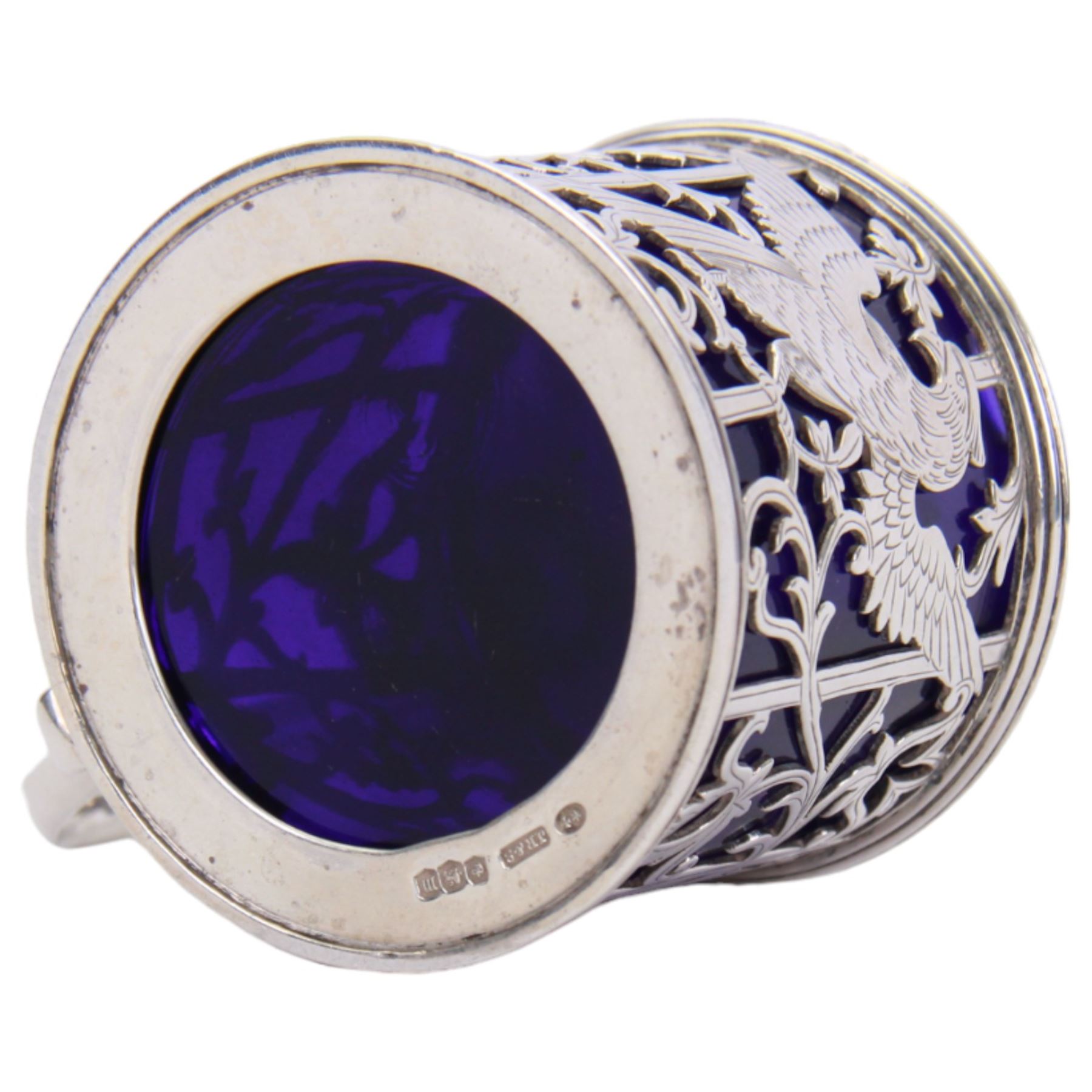 Early 20th century silver mustard pot and cover, of drum form the sides pierced with hound and birds in flight against leafy vines, the plain flat topped hinged cover with shell thumb piece opening to reveal a removable blue glass liner, hallmarked Joseph Rodgers & Sons, Sheffield 1929, including thumb piece H7cm