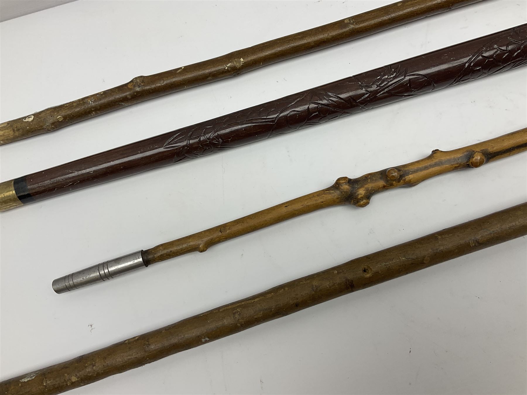 Four wooden walking canes, including a carved mahogany snooker cue example, tallest H86cm