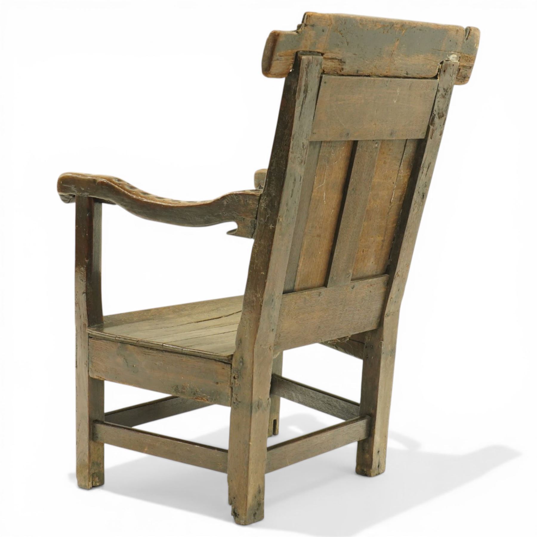 17th century Carolean oak Wainscot chair, the pokerwork cresting rail with carved geometric decoration, over a foliate carved back panel with arcade carved uprights, the arms with repeating guilloche carvings, raised on square chamfered supports united by castors