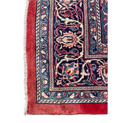 Persian Mahal crimson ground carpet, the field decorated with a central floral pole medallion, surrounded by scrolling foliate patterns and palmettes, the guarded indigo border with interlaced plant motifs