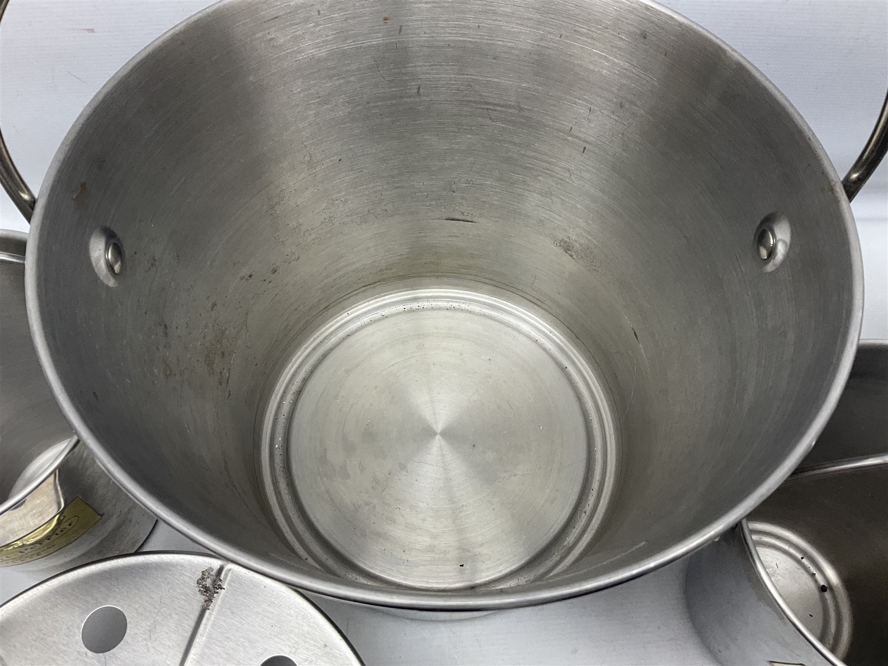 Stainless steel Laurent-Perrier champagne bucket, with engraved brass plaque and grip to swing handle, together with three matching smaller, largest D38cm (4)