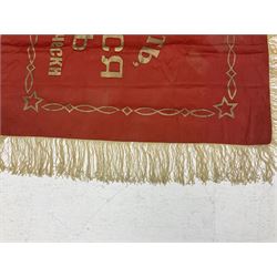1970s Soviet banner printed in gold on a red ground, roughly translates as 'Transferable Banner - To the winner in the Socialist Competition' and 'Work Study Live by Communism' verso; wreath of wheat ears to either side; tassels on three sides 110 x 155cm