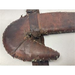 Eastern Jambiya, the 19cm double edge steel blade with raised medial ridge, waisted horn grip with pique work and white metal band; in stitched leather scabbard L33cm overall
