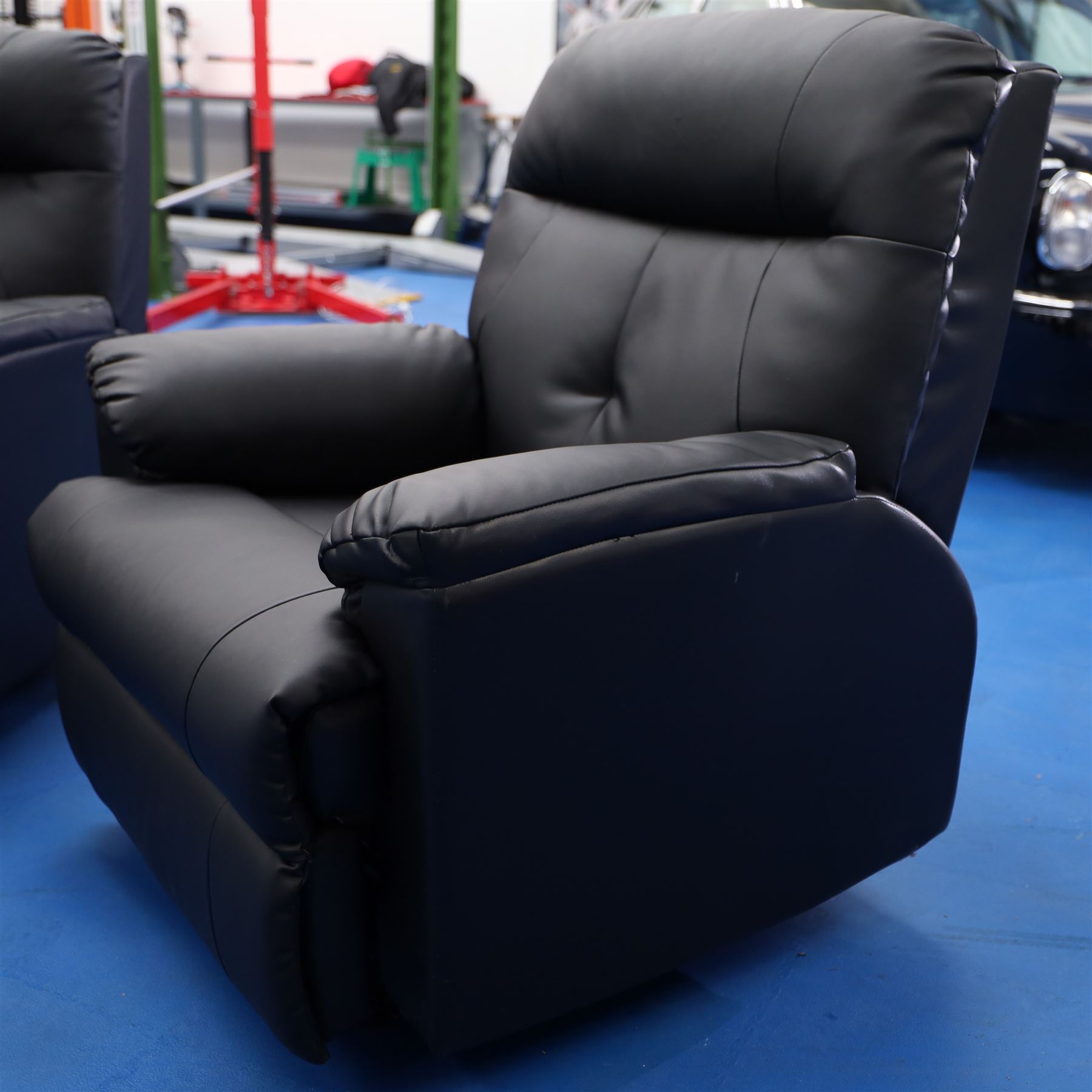 Two reclining armchairs upholstered in black faux leather