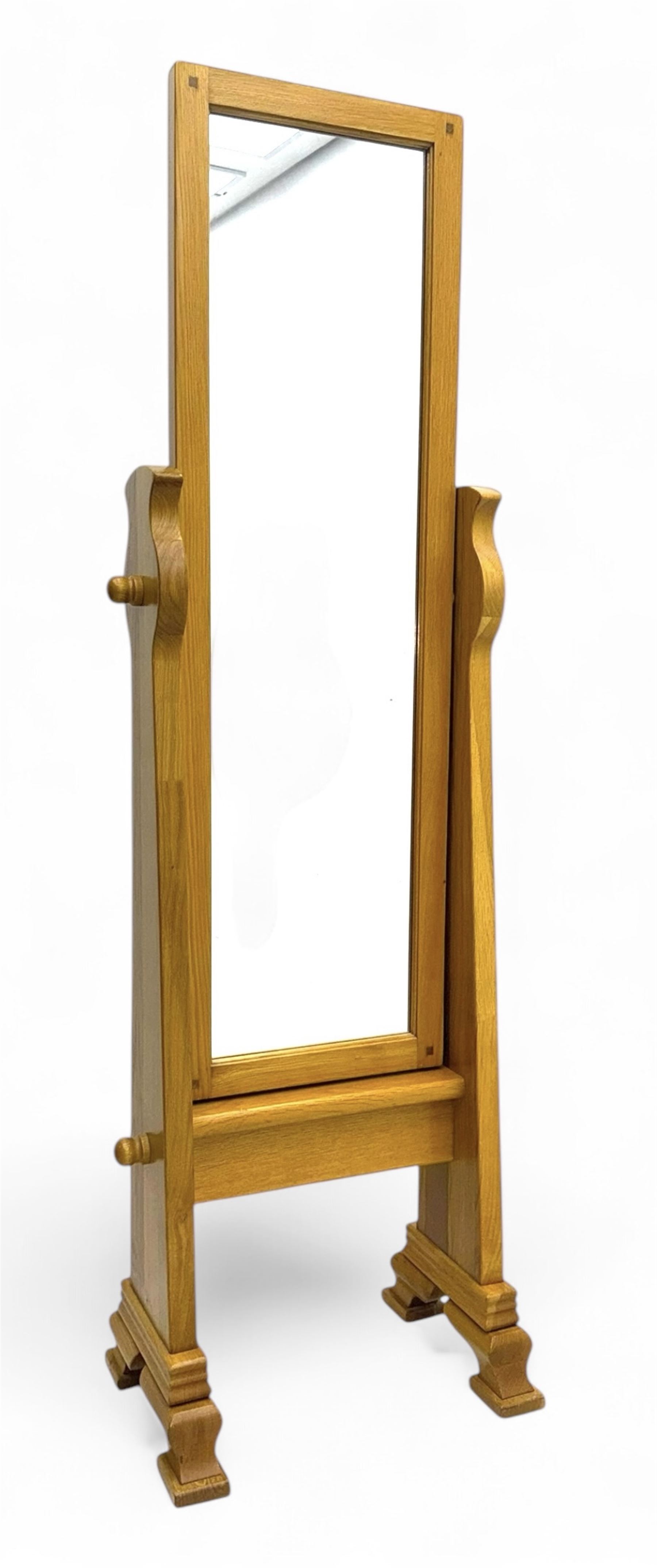 Contemporary light oak cheval dressing mirror, rectangular frame enclosing plain mirror plate, on shaped supports with turned finials, raised on stepped bracket feet