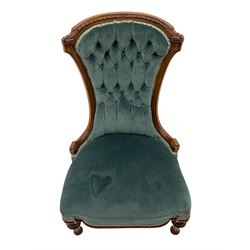 Victorian walnut framed nursing chair, the waisted back with arched cresting rail carved with foliate, buttoned back upholstered in blue fabric, turned and fluted supports with carved decoration 
