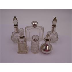 Six silver mounted cut glass dressing table bottles, including a pair with silver collars and a silver covered example with faceted stopper, all stamped or hallmarked, tallest H13cm