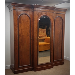  Victorian mahogany triple breakfront wardrobe, projecting cornice, central mirrored door enclosing pull out linen trays and graduating drawers, flanked by two panels doors with hanging space, plinth base, W213cm, H216cm, D70cm  