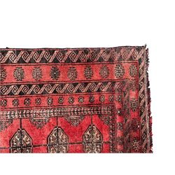 Afghan Bokhara red ground rug, the field decorated with three rows of Gul motifs, within multiple band borders decorated with trailing hook and geometric motifs 