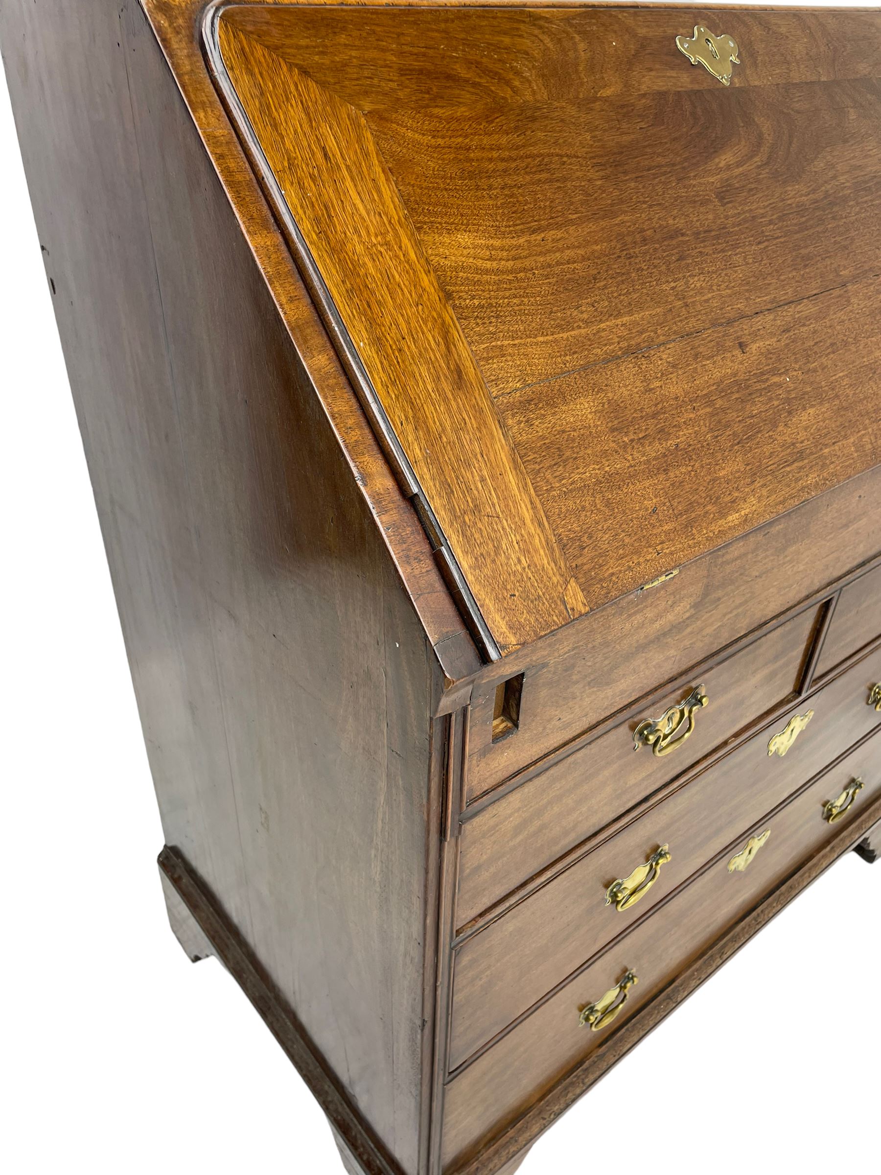 Georgian red walnut and mahogany bureau, moulded rectangular fall front with rounded upper corners, the interior fitted with sliding storage well, a combination of small drawers and pigeons holes, two short and two long drawers below, on bracket feet