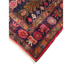 Kurdish red ground rug, decorated with plant motifs and stylised flower heads 