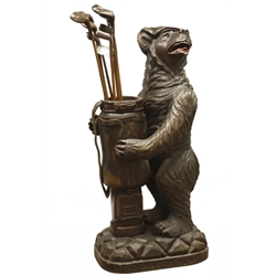  20th century Black Forest umbrella stand in the form of a snarling bear in a cap holding a golf club bag, on a rocky base, H120cm with a collection of hickory shafted woods and irons   