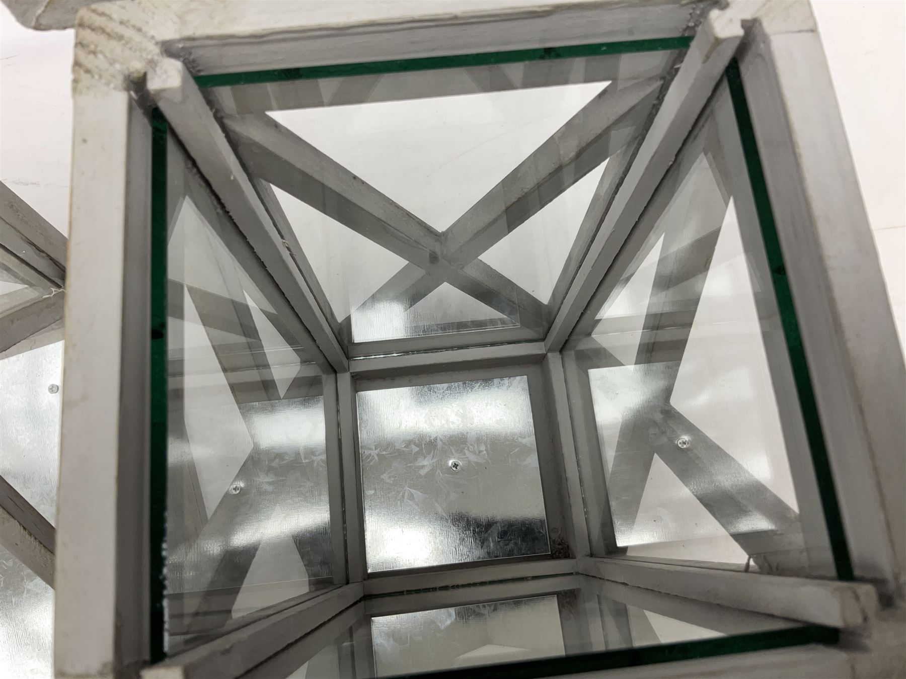 Two wooden lanterns with four glass sides, loop handles and open tops, largest example 58cm